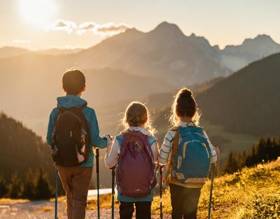 Drei Kinder die einen Waldweg entlang spazieren