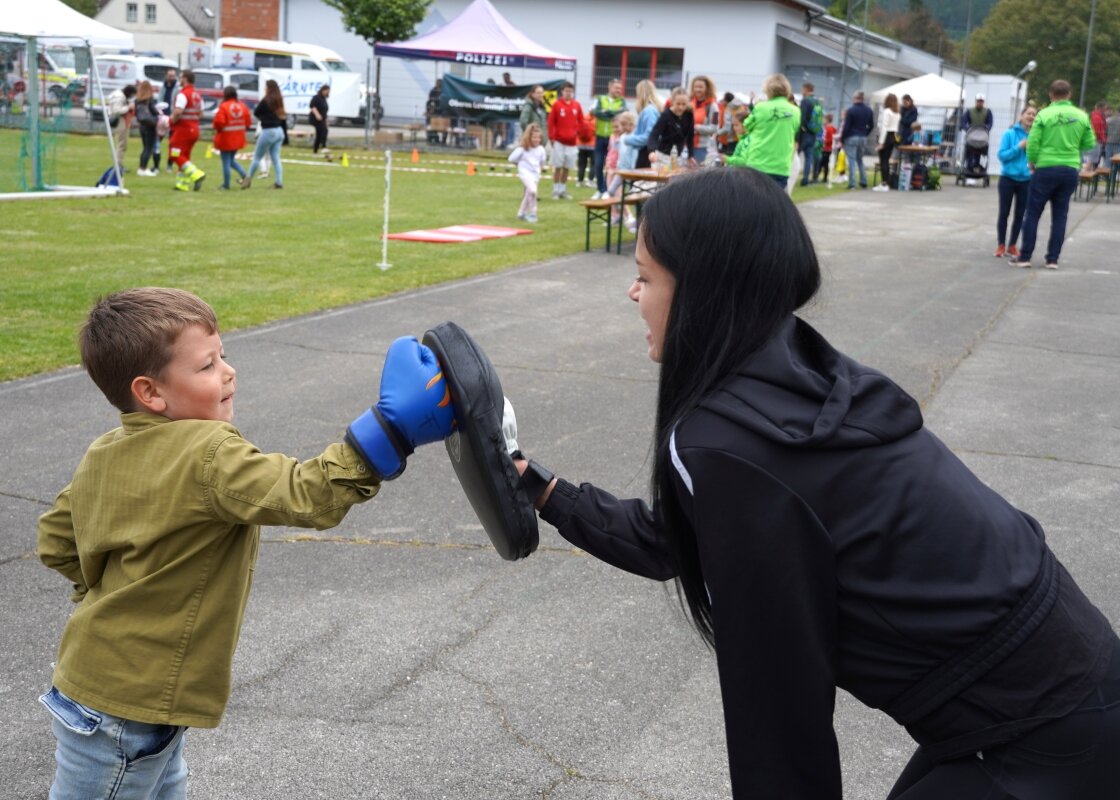 Ein Junge trainiert mit einer jungen Damen Jiu Jitsu